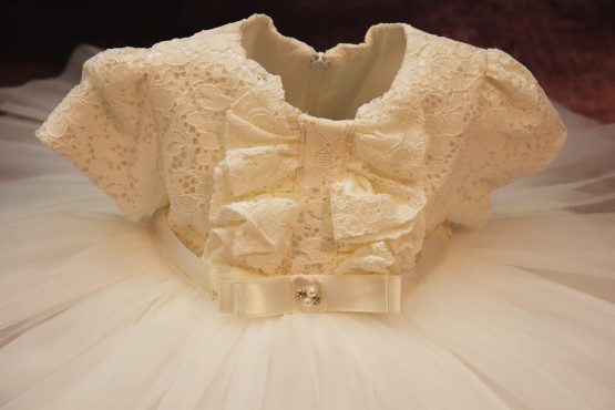 Rochiță de botez elegantă cu volănașe din dantelă pe piept -crem